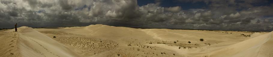 Die dunklen Wolken bilden den perfekten Kontrast zum hellen Sand