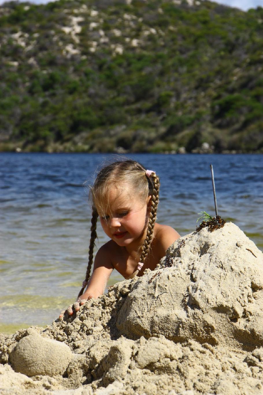 Annabell versucht sich als Sandburg-Architekt.