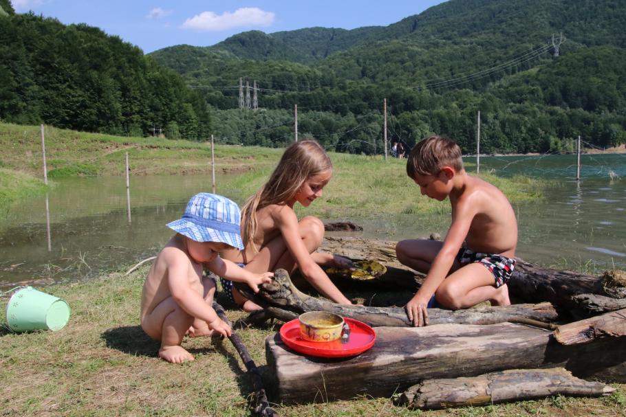 Die Kinder bauen aus Treibholz eine Burg.