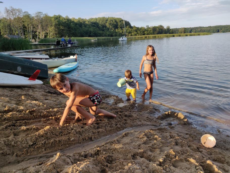 Die Kinder beginnen instinktiv mit Bauarbeiten am Strand.