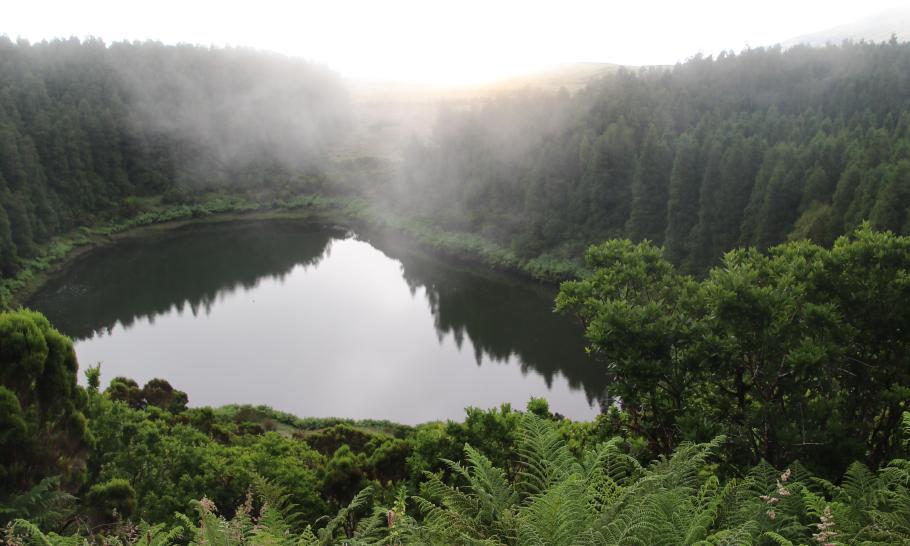 Die Sonne hängt hinter den Wolken. Ein paar Sonnenstrahlen werden vom Meer reflektiert.