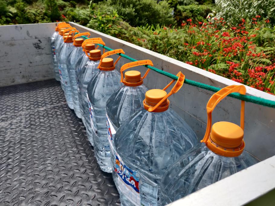 Die Einheimischen kommen im Pick-Up mit reichlich Behältern zur Quelle