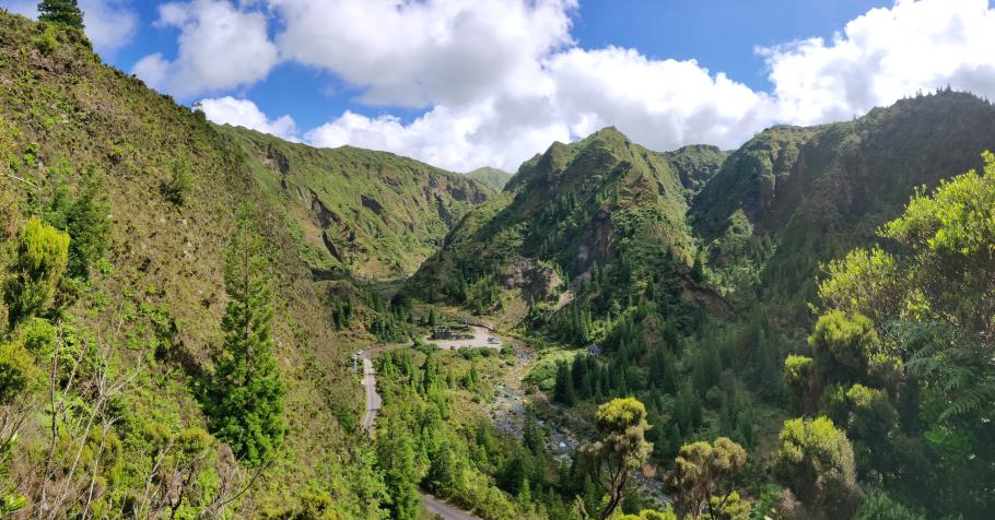 Eine schmale Kopfsteinpflasterstraße führt hinab ins Tal