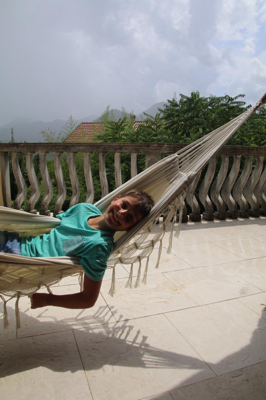 Felix genießt die Hängematte, während Annabell die Restaurant-Katzen streichelt