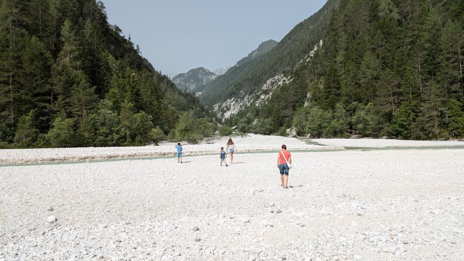 Im Bett aus schneeweißem Geröll plätschert ein Fluss, der den See mit frischem Wasser versorgt
