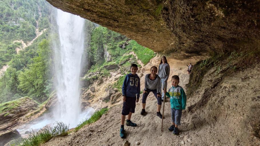 Ein schmaler Weg führt unter dem Wasserfall entlang