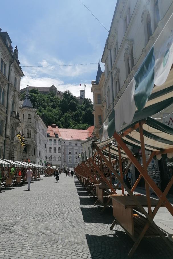 Hier werden gerade Marktstände aufgebaut. Im Hintergrund ist die Burg von Ljubljana