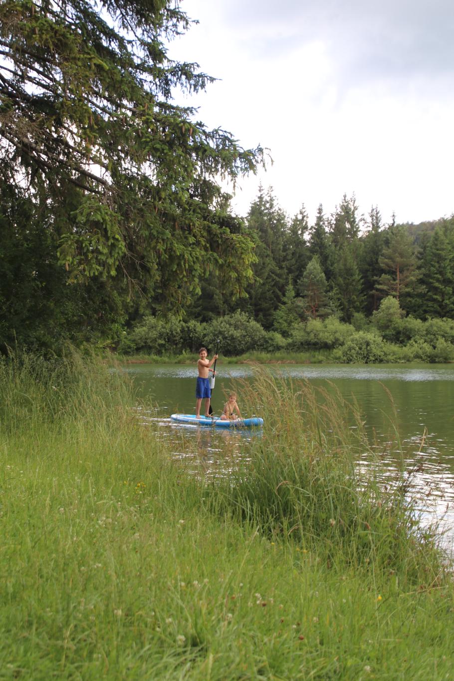 Die Jungs erkunden den See auf dem Standup-Paddle-Board