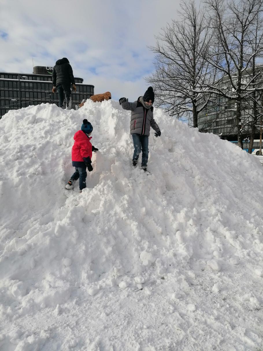Die Jungs sind begeistert von den hohen Schneehaufen, die in der ganzen Stadt zu finden sind.