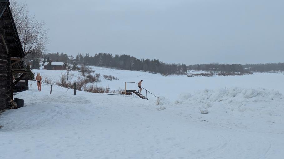 An der nächsten Flussüberquerung kommen Leute in Badesachen aus der Sauna.